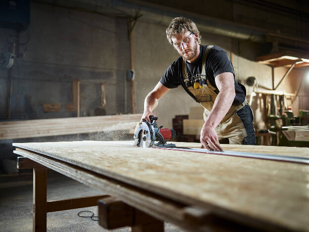 Zimmermann mit Handkreissäge schneidet OSB Platte, Industriefotografie Christian Vorhofer 