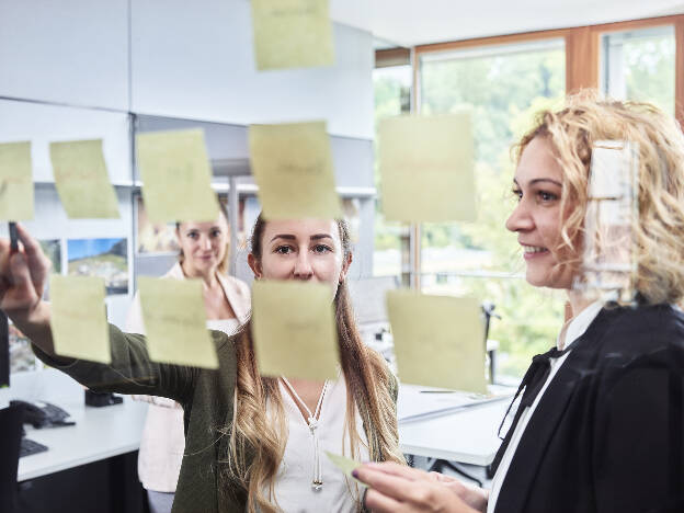 Frauen hängen Post It während Meetings an Glaswand - Businessfotograf Businessfotografie Christian Vorhofer