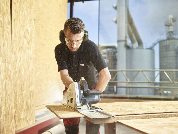 Egger Mitarbeiter schneidet OSB Platte mir Handkreissäge in Wismar, Industriefotografie Christian Vorhofer 